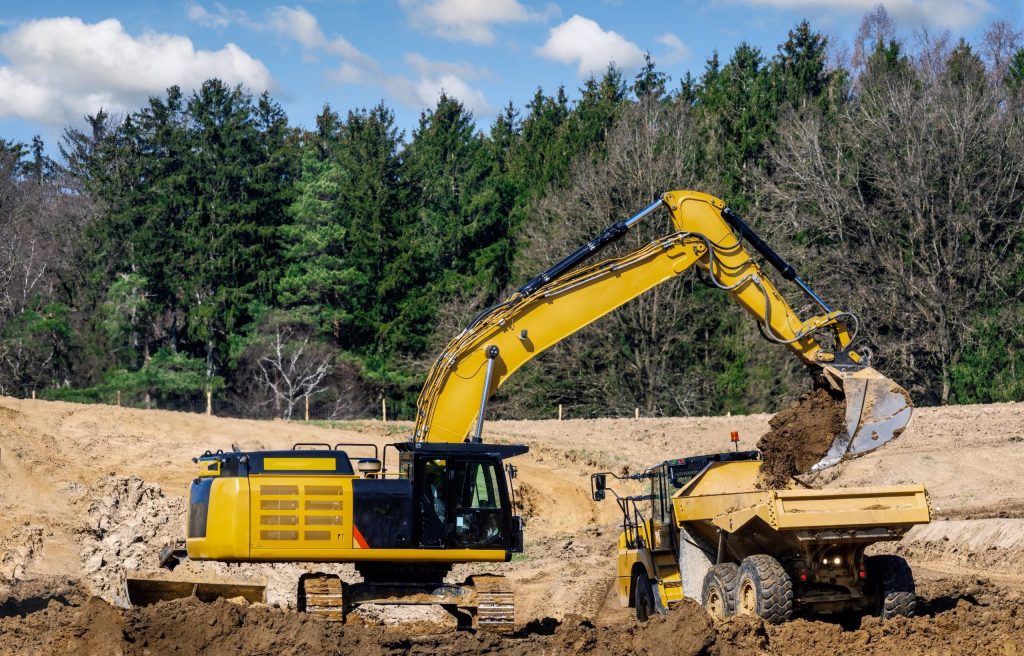 Yellow earth mover at a construction site Yellow earth mover filling a lorry at a construction site